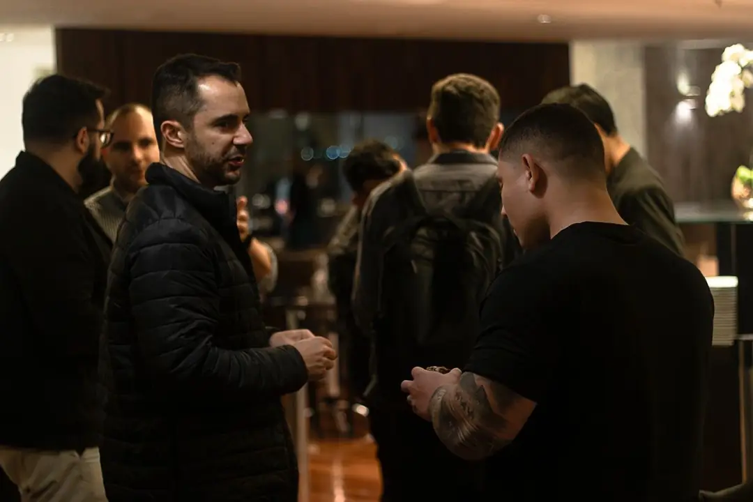 Participantes conversando em pé no corredor