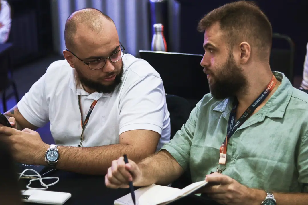 Dois participantes trabalhando juntos com o caderno aberto